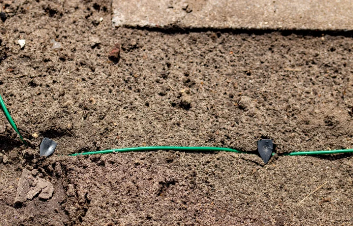 Grünes Kabel auf Erde